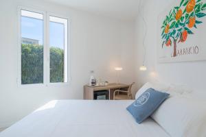 a white bedroom with a bed and a window at Dimore delle Zagare Molo in Syracuse