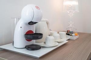 a white coffee maker sitting on a shelf with cups at Dimore delle Zagare Molo in Syracuse