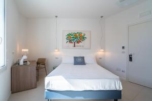 a bedroom with a bed and a table with a telephone at Dimore delle Zagare Molo in Syracuse