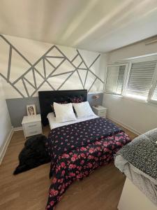 a bedroom with a bed with a black and white comforter at Appartement proche de La Défense in Puteaux