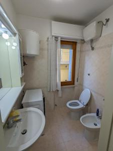 a bathroom with a sink and a toilet and a window at Il granchio in Marcelli +11 photos