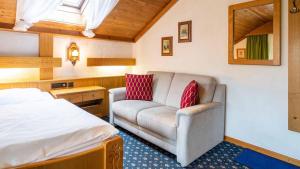 Hotel Alpina في هاغنو: غرفه فندقيه بسرير واريكه
