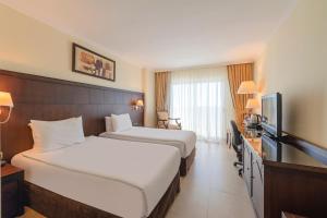 a hotel room with two beds and a flat screen tv at Crowne Plaza Antalya, an IHG Hotel in Antalya