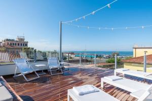 balkon z krzesłami i widokiem na ocean w obiekcie Residence Stella w mieście Marina di Massa