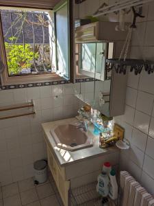 łazienka z umywalką i oknem w obiekcie Les Chaises w mieście Raizeux
