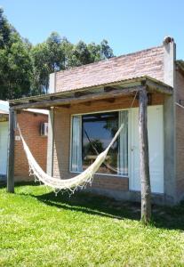 a hammock hangs from the side of a house at Bungalows Tiempo Libre in Colón