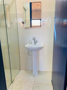 une salle de bain avec un lavabo et un miroir dans l'établissement Casinha colibri, à Conceição da Ibitipoca