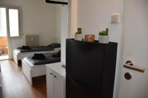 a room with two beds and a black refrigerator at Zentrales Studio-Apartment in Linz in Linz