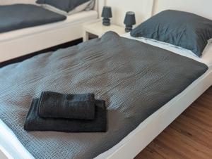 Una cama con una manta negra encima. en Zentrales Studio-Apartment in Linz, en Linz