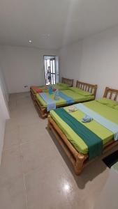 3 camas están alineadas en una habitación en Diniwid Garden Beach, en Boracay