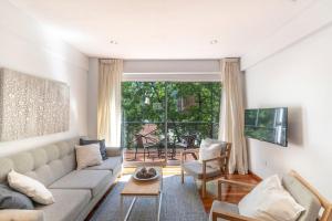 a living room with a couch and a large window at Dúplex muy amplio para familias | Las Cañitas in Buenos Aires