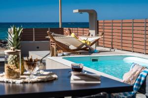 una mujer sentada en una hamaca junto a una piscina en Anasa Luxury Villas with Heatable Pool, en Kokkíni Khánion 66 fotos más