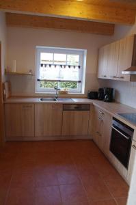 una cucina con un lavandino e una finestra di Ferienvilla "Lara's Olle Warft" a Krummhörn