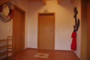 un corridoio con una porta con un cappotto rosso di Ferienvilla "Lara's Olle Warft" a Krummhörn Altre 13 foto