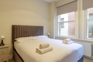 a bedroom with a bed with two towels on it at Dublin Castle Suites in Dublin
