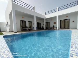 a villa with a swimming pool and a house at Villa Tazerzit comfort et hospitalité in Essaouira