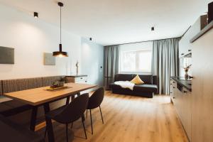 a kitchen and living room with a table and a couch at Apart Himmel-Raich in Kaunertal