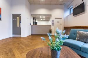 a living room with a blue couch and a table at For Students Only Mealmarket Exchange in Aberdeen in Aberdeen +8 photos