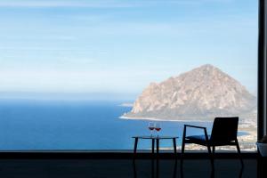 a table and a chair and a glass of wine at Hotel Venere di Erice Resort & Spa in Valderice