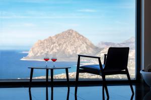 two glasses of wine on a table in front of a window at Hotel Venere di Erice Resort & Spa in Valderice