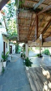 an outdoor patio with a wooden ceiling and plants at Casa ampla com Wi-Fi e garagem para dois veículos in Campos dos Goytacazes