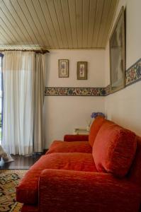 a red couch in a room with a window at A Casa da Fazenda in Santo Antônio do Pinhal