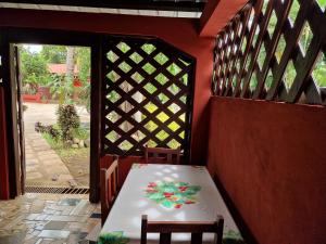 a table and chairs in a room with a door at Bungalow chez Mouch Nosy-Be 2 in Nosy Be