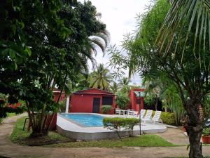 a swimming pool in the middle of a yard with trees at Bungalow chez Mouch Nosy-Be 2 in Nosy Be