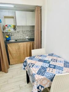 een keuken met een tafel en een quilt bij Vacanza Azzurra in Porto Cesareo