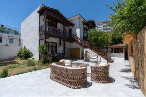 eine Terrasse mit Rattanstühlen und ein Gebäude in der Unterkunft My Hotel in Antalya