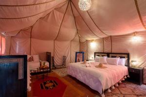 a bedroom with a bed in a tent at riad luz merzouga in Merzouga