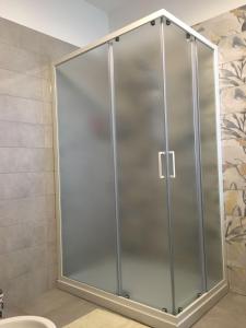 a shower with a glass door in a bathroom at Casa Gatti: villa con giardino con accesso indipendente in Rivanazzano