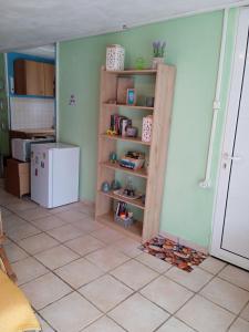 een keuken met een boekenplank en een koelkast bij PRIVATE SEASIDE GUEST HOUSE... in Agia Marina Mikrolimanou