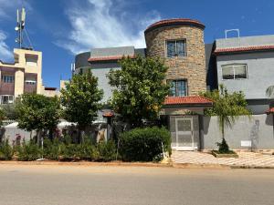 a building with a tower on the side of a street at Dar el kebira in Meknès