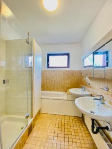 a bathroom with two sinks and a tub and a shower at Family room in Am Schöpfwerk area in Vienna