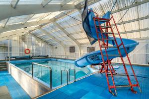 a water slide in a pool with a ladder next to it at Tasman Holiday Parks - Christchurch in Christchurch