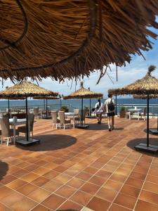 a person walking down a patio with tables and umbrellas at Manolya Hotel in Kyrenia