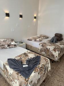 a room with three beds with blankets on them at Pousada Rabake in Aparecida +94 photos