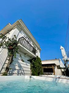 a house with a swimming pool in front of a building at Pousada Villa D Manu in Penha