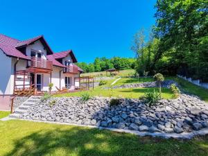 een huis met een rotstuin ervoor bij Srokówka Resort in Dąbrówka