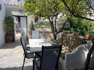 a table and chairs on a patio with a tree at Lemon House in Hydra