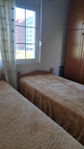 2 camas en un dormitorio con ventana en Nevi House en Berat