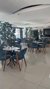una sala da pranzo con tavoli, sedie e piante di Manolya Hotel a Kyrenia