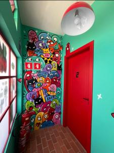 a hallway with a wall covered in cartoon characters at Pousada Bat N Breakfast No Beco do Batman in São Paulo