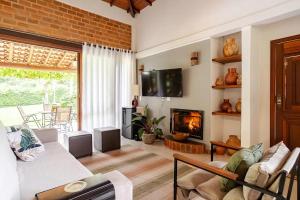 a living room with a couch and a fireplace at Casa de campo Secretário/ Pedro do Rio RJ in Petrópolis
