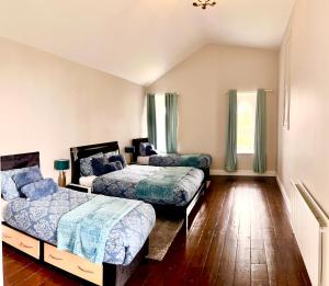 two beds in a room with wooden floors at Skryne Castle in Ross Cross Roads