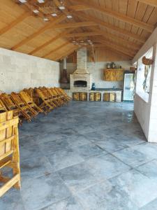 a large room with a stone floor and wooden ceiling at Nika Hangstigoti in Ptykhni