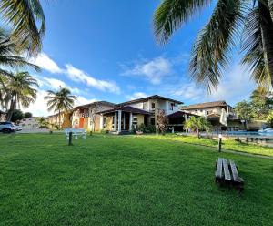 a park with a bench in front of a house at Apto/Hotel Praia Taperapuã - Beira Mar in Porto Seguro