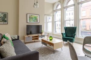 Dublin Castle Suites في دبلن: غرفة معيشة مع أريكة وتلفزيون