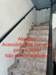 un escalier avec un panneau latéral dans l'établissement Pousada Rabake, à Aparecida